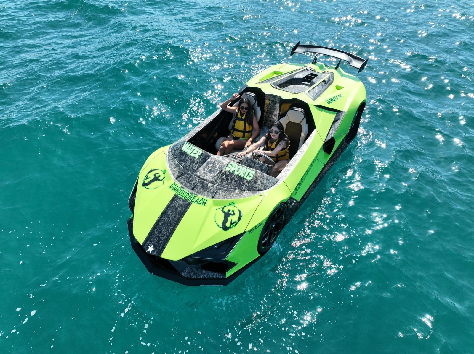 Two guests in a green jet car surrounded by clear turquoise water