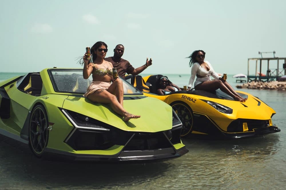 Guests gathered with the green and yellow JetCarsBelize jet cars at Secret Beach